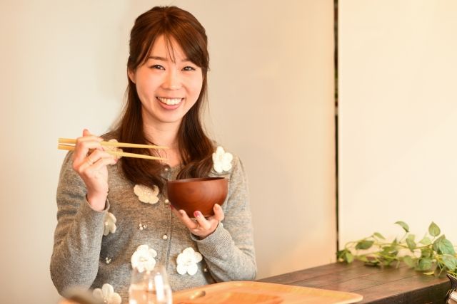 お椀と箸を持っている女性